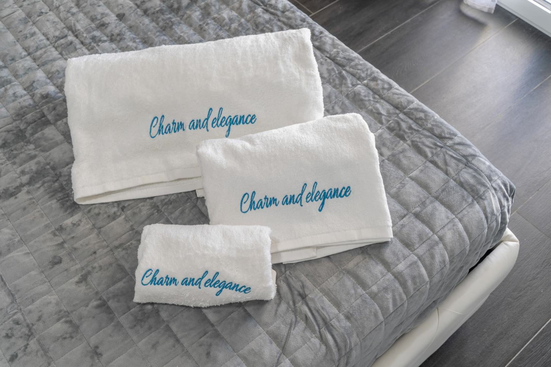 Gli asciugamani ricamati con il nome della villa, sul letto della camera Sole