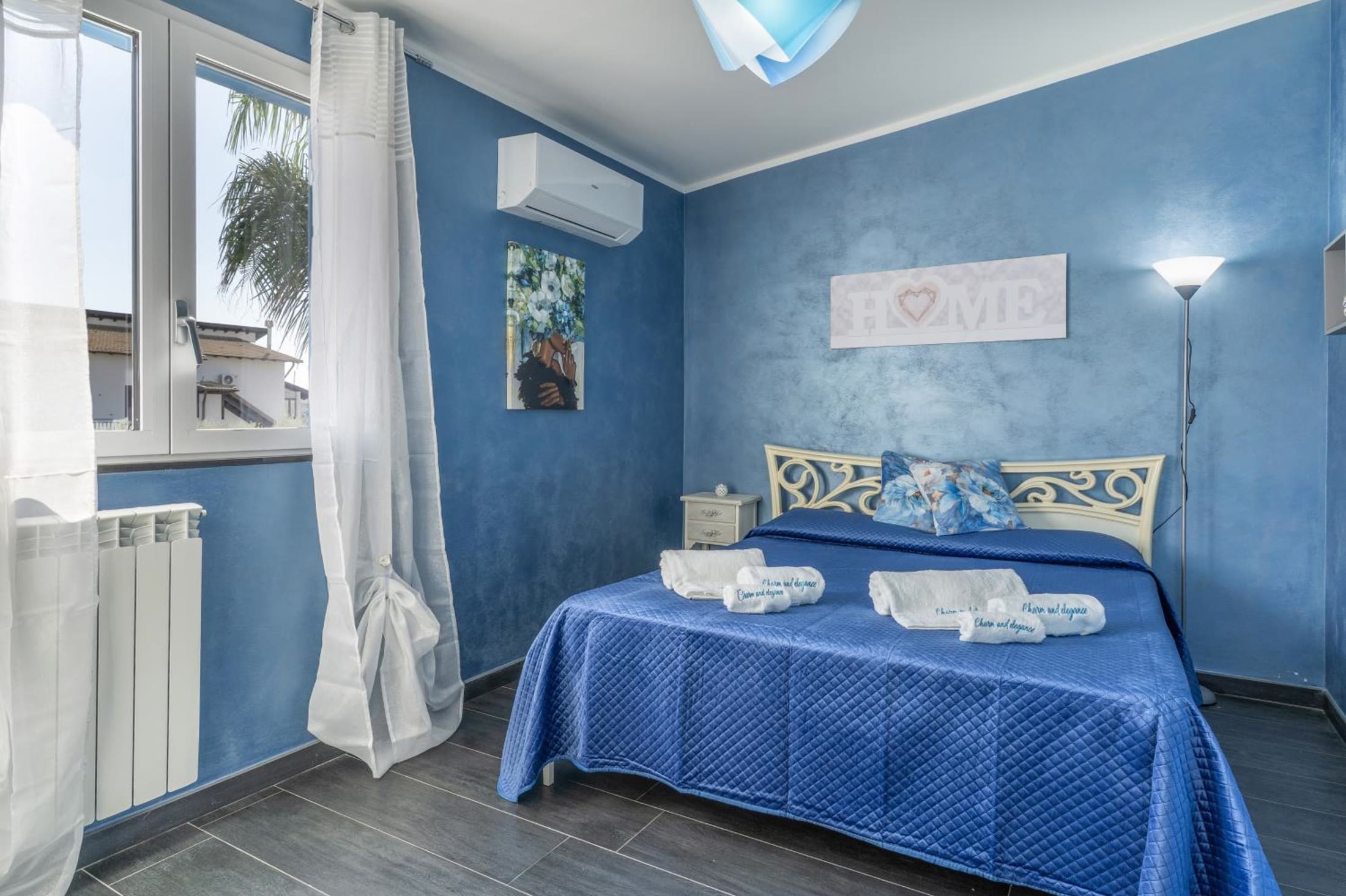 Camera Stella: le pareti blu, il letto matrimoniale e il climatizzatore