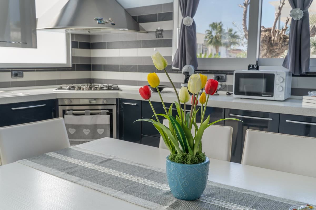 Il piano cottura, il forno e il microonde, con i tulipani sul tavolo