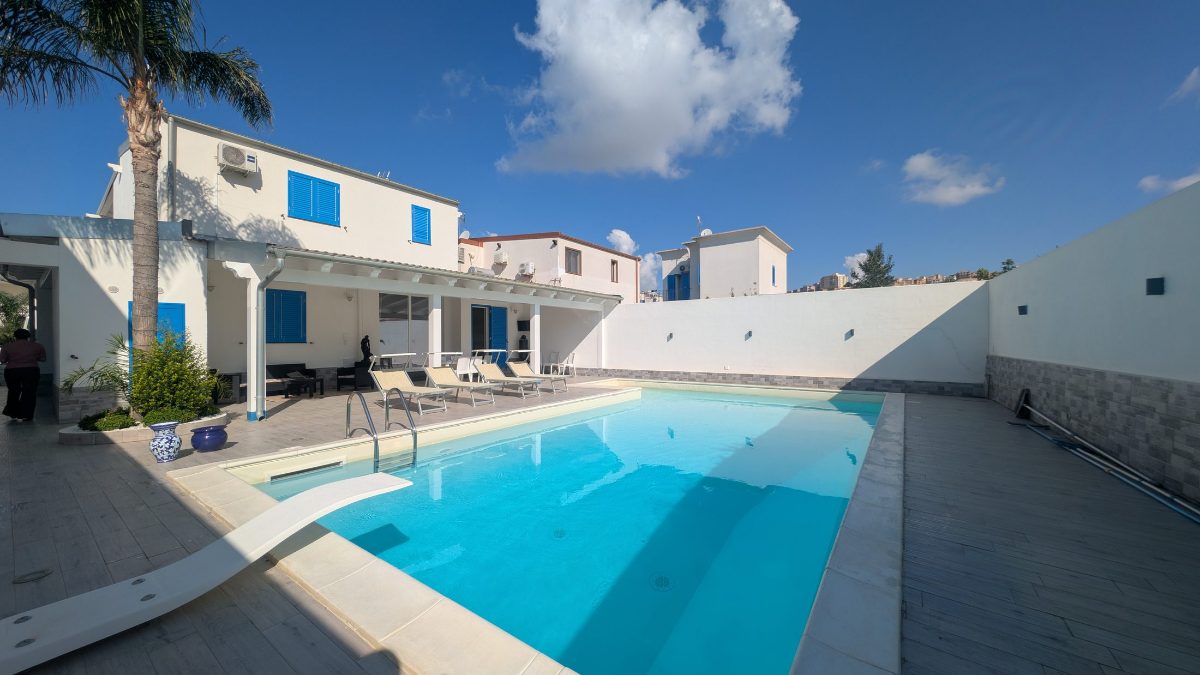 La piscina vista dall'angolo, con le palme in primo piano