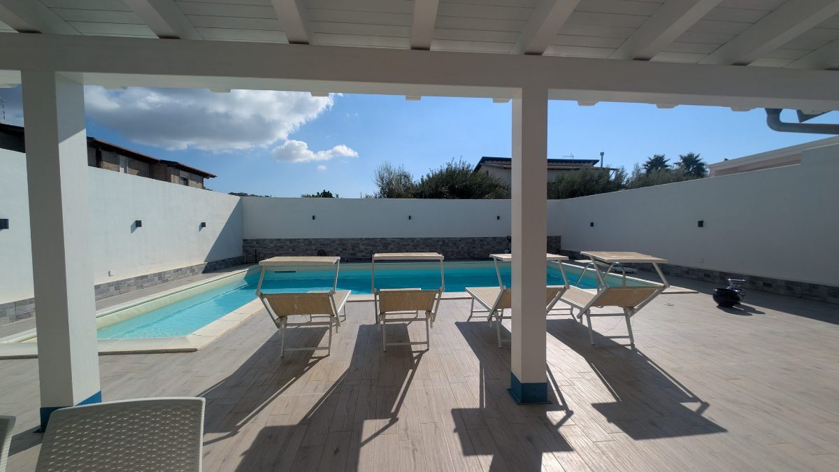 I lettini all'ombra del pergolato, a bordo piscina