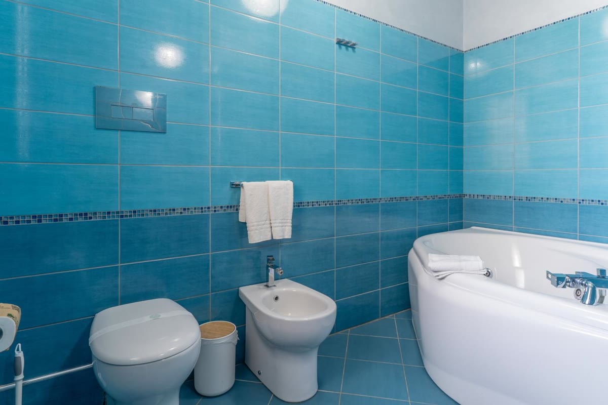 The blue bathroom with the corner whirlpool bath
