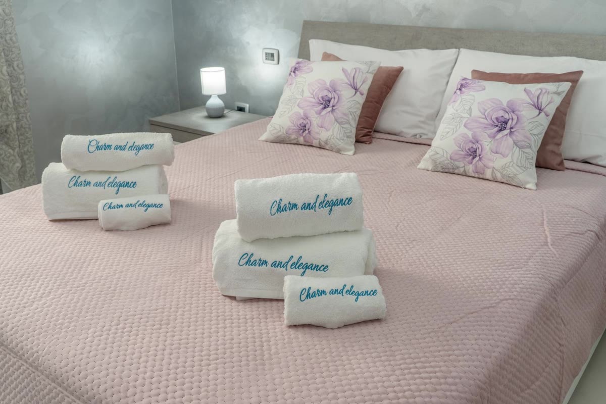 Towels embroidered with the villa's name, on the pink bedspread in the Nuvola room