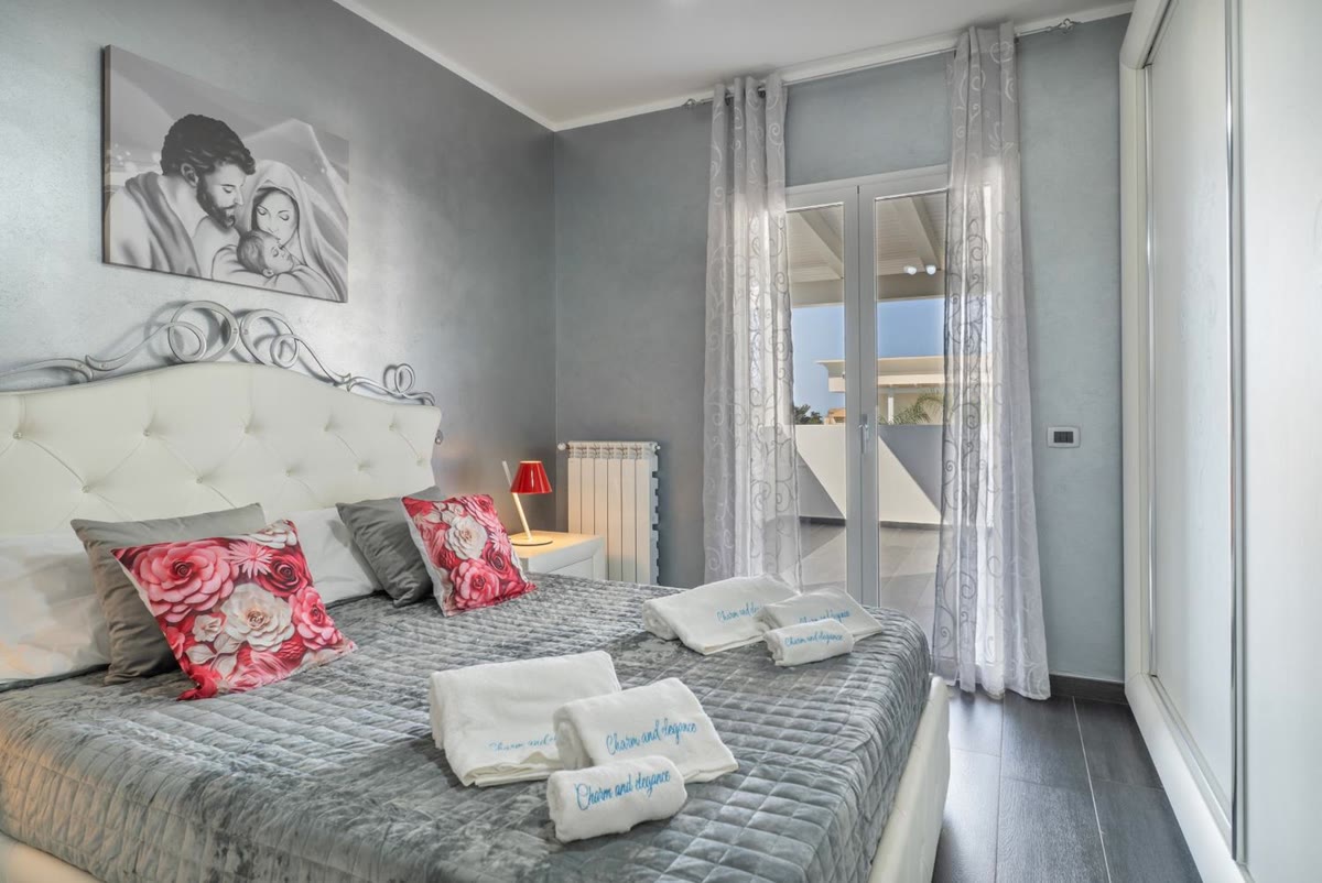 Sole bedroom: the bed with its buttoned headboard and the French window