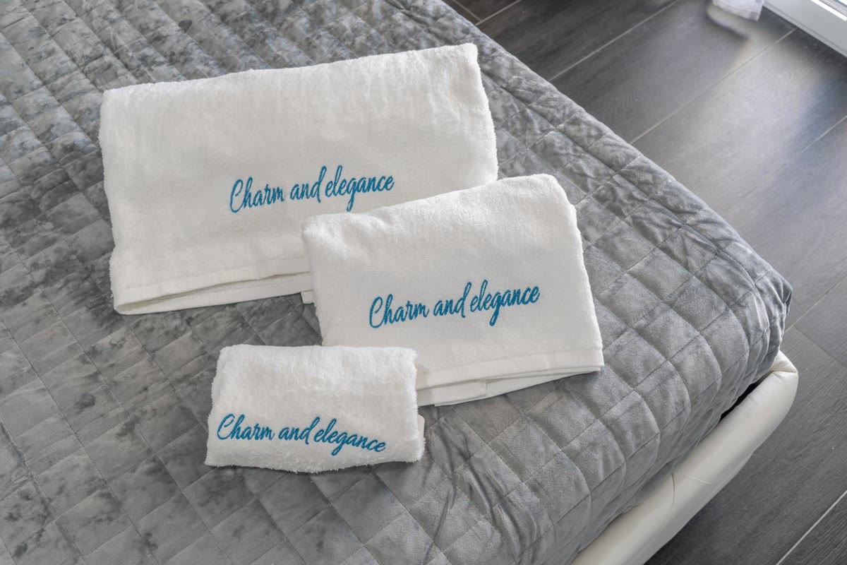 Towels embroidered with the villa's name, on the bed in the Sole room