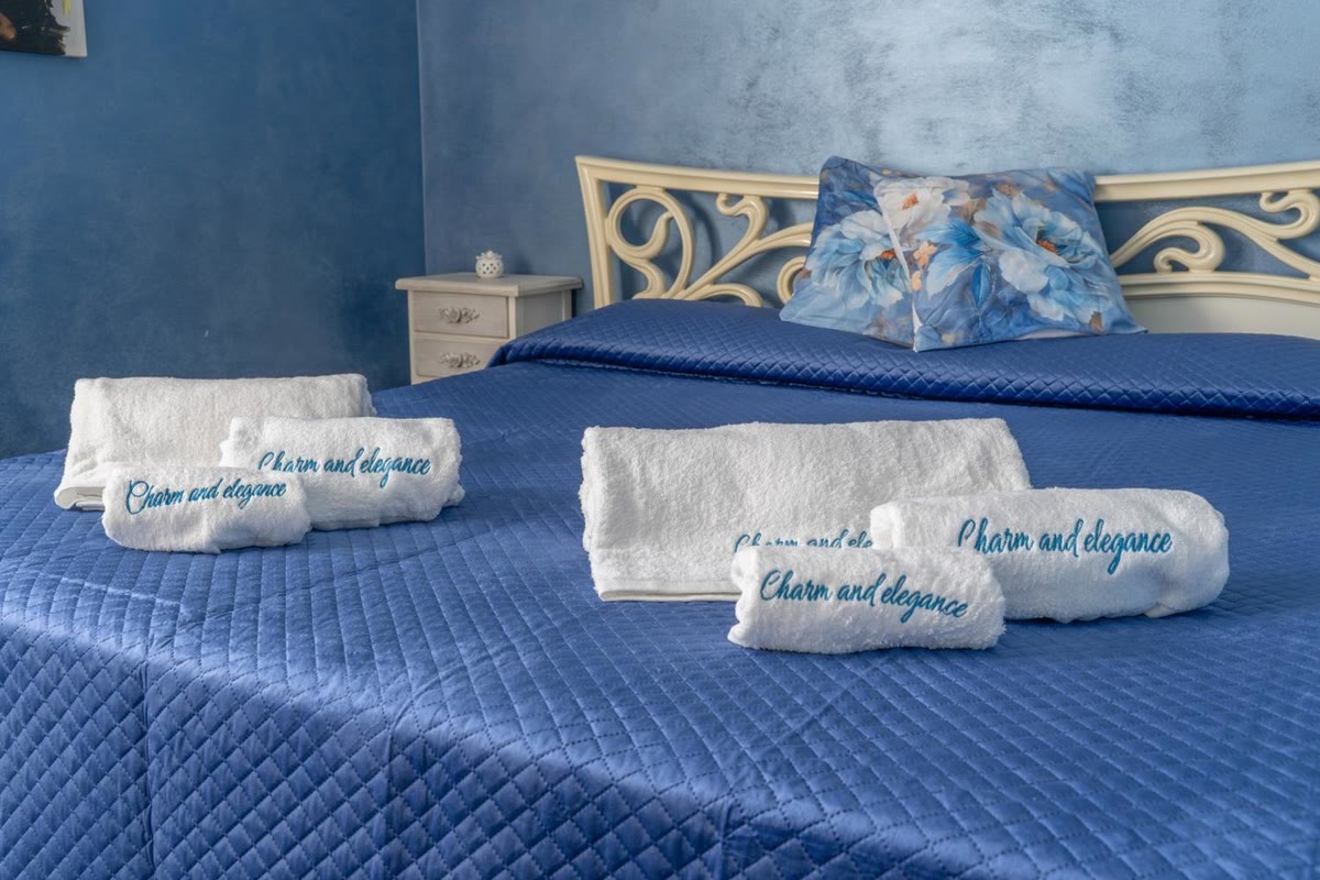 Towels embroidered with the villa's name, on the blue bedspread in the Stella room