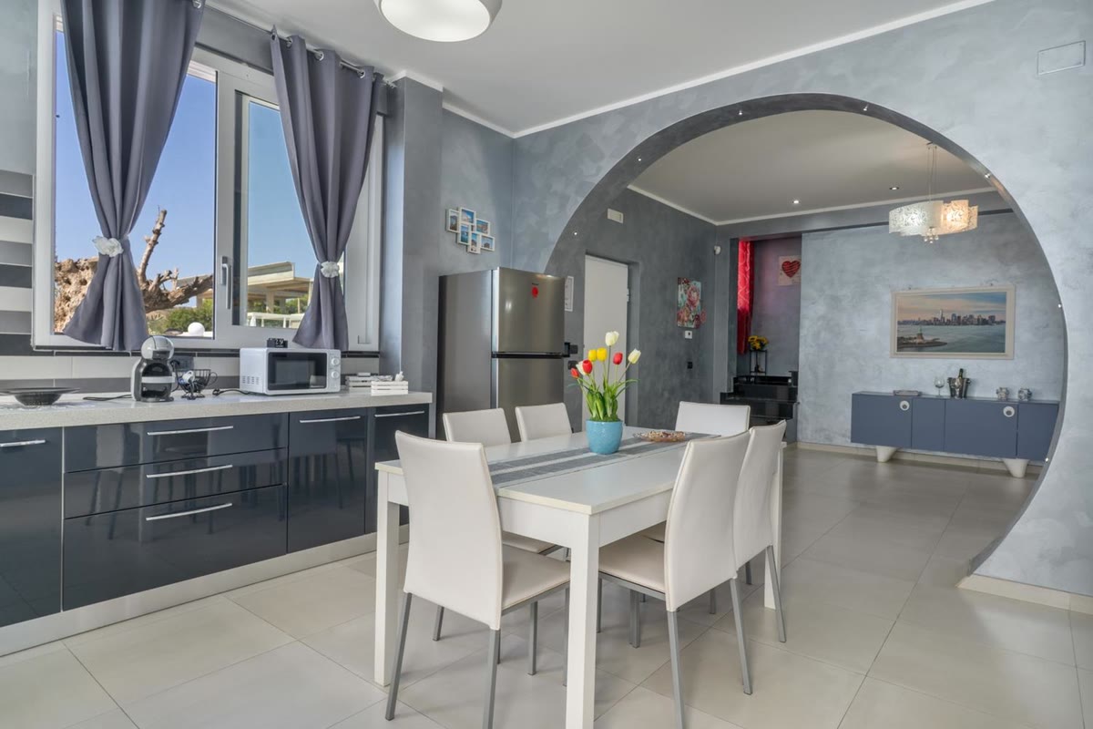 The kitchen with the dining table and the arch towards the living room