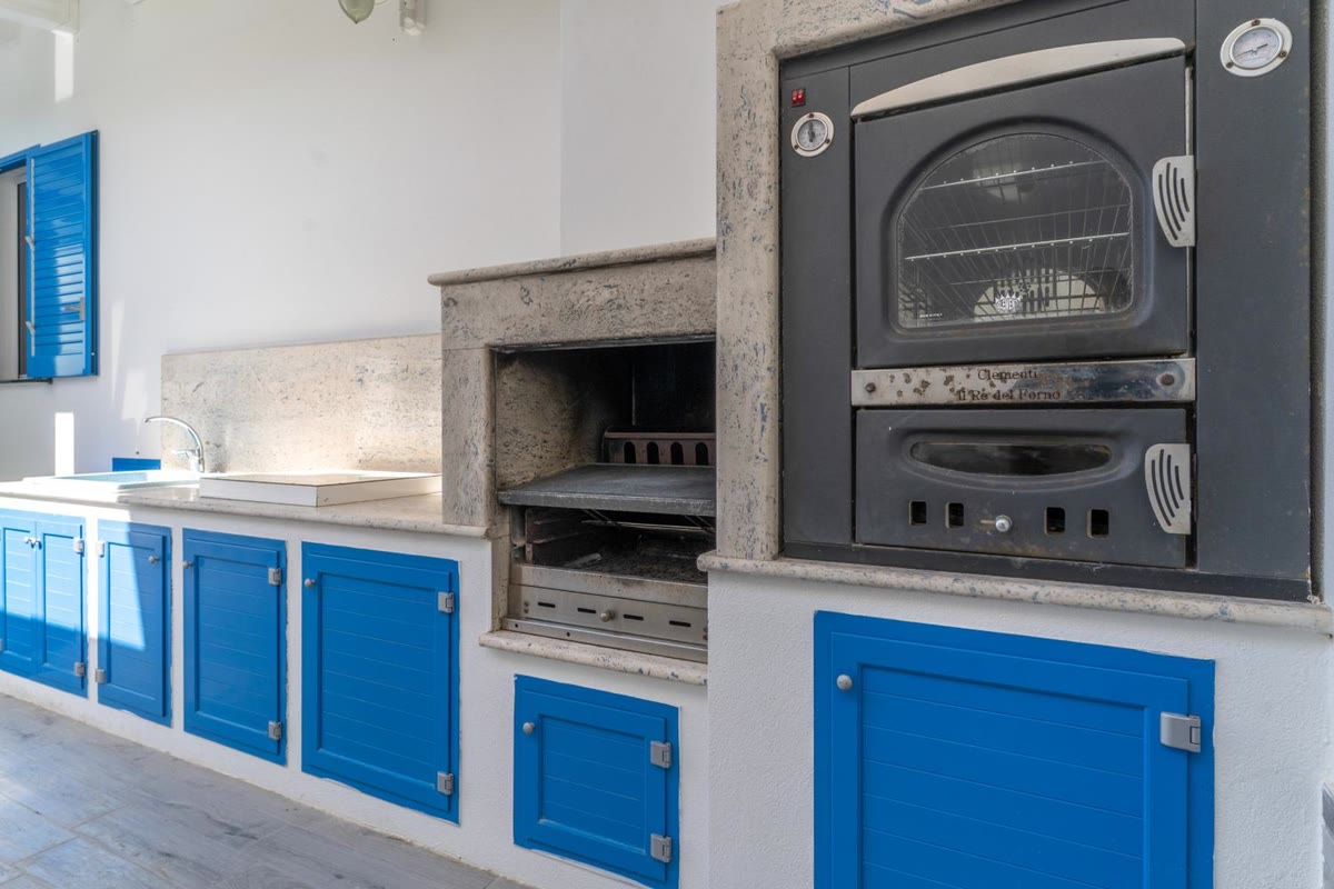 The outdoor kitchen with barbecue and wood-fired oven