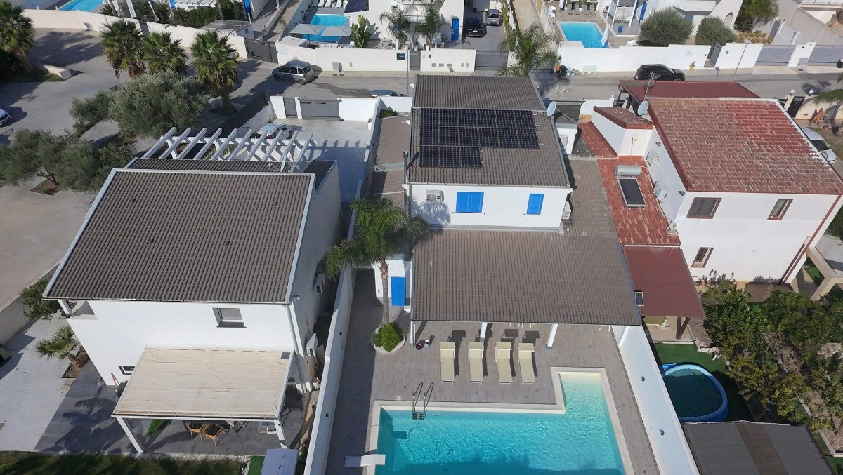 The villa and the pool from above, with the houses around