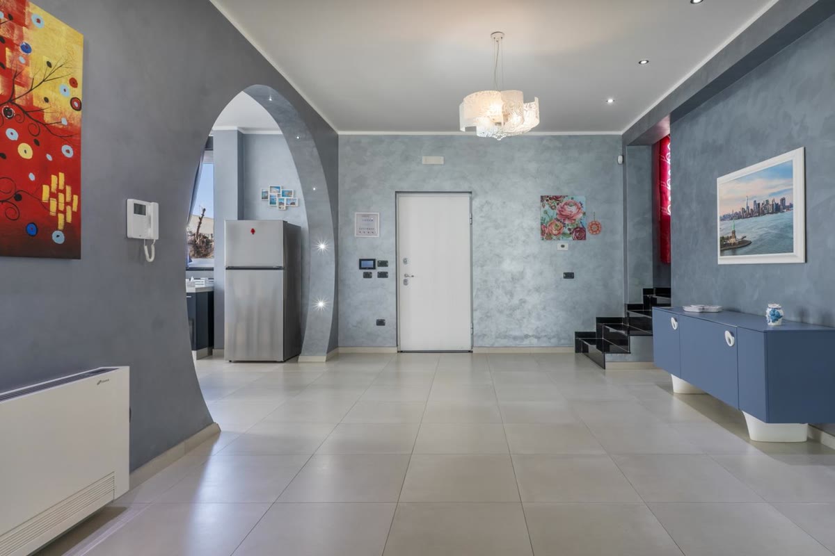 The entrance hall, with the front door, the stairs and the arch to the kitchen